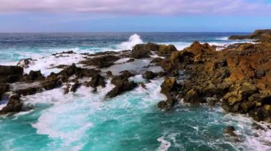 Kayalık sahilde hoş bir deniz sörfü. Seyahat için turistik bir yer