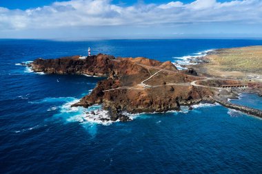 Atlantik Okyanusu 'nun manzarası ve bir ada. Güzel dalgalar güçlü kayalara bir deniz feneriyle vurur.