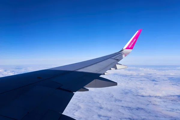 Varşova, Polonya - 14 Mart 2023 - Havayolu logosu olan bir uçak yüksek irtifada uçuyor. Wizzair Airbus uçağından görüntü