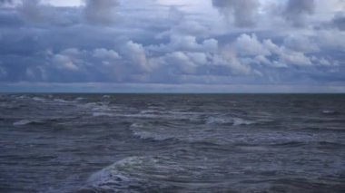 Fırtınalı bir gökyüzüne karşı deniz dalgaları. Kuşlar suyun üzerinde uçar