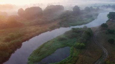 İnanılmaz bir sabah yaz manzarası. Güneşin doğuşunda yukarıdan manzaralı güzel bir doğa. Nehrin üzerinde sis