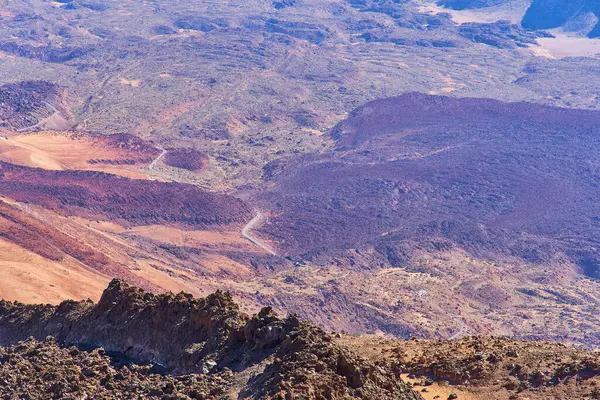 一条小路在火山的火山口内退缩到远处 山区的空中摄影 — 图库照片