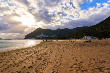 Atlantik Okyanusu 'nun sakin sahili, sarı kumla kaplı dağların arkasındadır.
