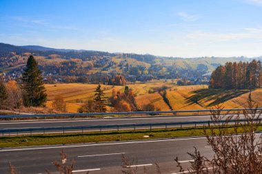 Kırsal kesimde güneşli bir günde renkli tepe manzarası. Dağlara yolculuk, maceraya yol.