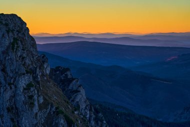 Dağlarda renkli bir cennet, gökte parlak bir güneş ışığı. Gözlem günü değişiklikleri