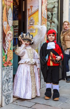 Venedik, İtalya - 18 Şubat 2012: Venedik Karnaval günlerinde geleneksel bir dükkanın önünde poz veren iki çocuğun resmi