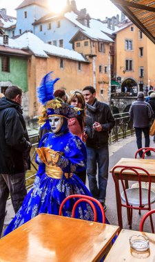 Annecy, France- February 23, 2013: Environmental portrait of an unidentified person disguised in a beautiful costume walking in the street in Annecy, France, during a Venetian Carnival, which is held yearly, to celebrate the beauty of the real Venice