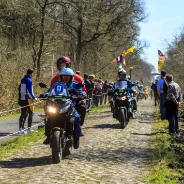 Wallers-Arenberg, Fransa - 12 Nisan 2015: Fotoğrafçıların resmi bisikletleri Paris-Roubaix bisiklet yarışı sırasında bisikletçilerin geçmesinden önce, ünlü asfaltlı sektör olan Arenberg uçurumunu (Trouee d 'Arenberg) takip ediyor..