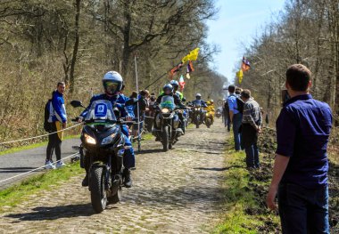 Wallers-Arenberg, Fransa - 12 Nisan 2015: Fotoğrafçıların resmi bisikletleri Paris-Roubaix bisiklet yarışı sırasında bisikletçilerin geçmesinden önce, ünlü asfaltlı sektör olan Arenberg uçurumunu (Trouee d 'Arenberg) takip ediyor..