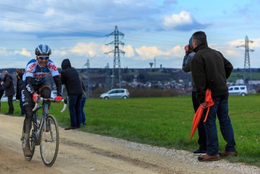 Vendome,France- March 7,2016:The French cyclist Tony Gallopin of  Team Lotto Soudal rindes on a dirty road,Tertre de la Motte, in Vendome, during the first stage of Paris-Nice 2016. clipart