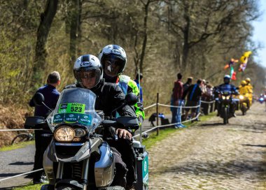 Wallers-Arenberg, Fransa - 12 Nisan 2015: Bir fotoğrafçının resmi bisikleti Paris-Roubaix bisiklet yarışı sırasında bisikletçilerin geçmesinden önce ünlü asfalt sektörü Arenberg 'e (Trouee d' Arenberg) gider..
