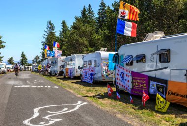 Cote de la Fage, Fransa - 16 Temmuz 2022: Le Tour de France 2022 'nin 14. safhasında Cevennes Dağları' ndaki Cote de la Fage 'in yol kenarında hayranları tarafından dekore edilmiş kamp arabalarının yanından geçen tanımlanamayan amatör bisikletçiler.