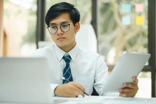 年轻的专业人士和专心致志的商人 戴着眼镜 坐在办公室的办公桌前 一边工作 一边分析数据 一边计划商业策略 以提高销售利润 — 图库照片