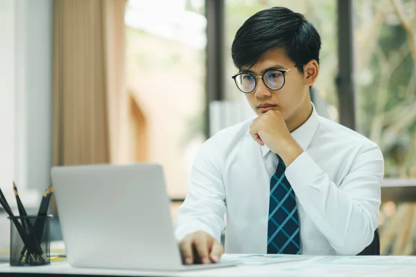 年轻的专业人士和专心致志的商人 戴着眼镜 坐在办公室的办公桌前 一边工作 一边分析数据 一边计划商业策略 以提高销售利润 — 图库照片
