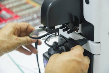 Tıbbi optik klinikteki hastadan kopyalanan yeni gözlük merceğini yapan, kontrol eden ve düzelten profesyonel bir gözlükçü..