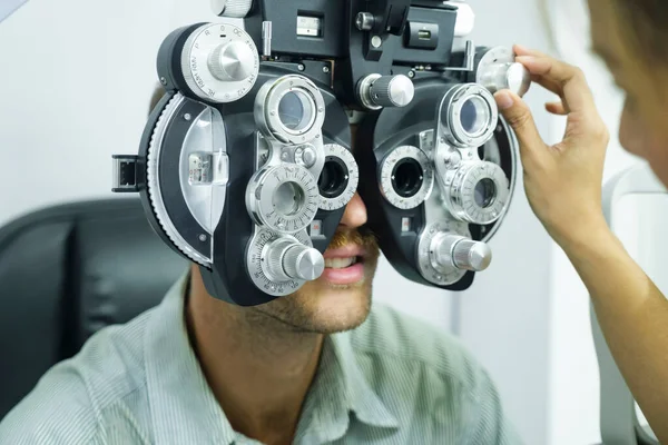 目の検査 目の検査 臨床検査機のフォトパーを使用して専門家によるチェックを持つスマートハンサムな男は 光店で新しい眼鏡を作るために — ストック写真