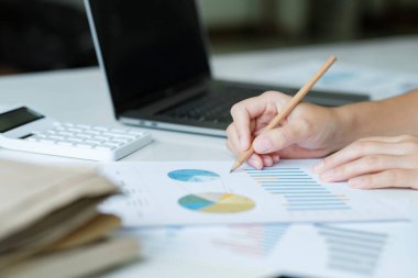 Genç Asyalı iş kadınının ofiste bilgisayardaki veri grafiklerini kullanarak, iş büyümesi için geliştirme, çözümleme ve strateji planlayarak sıkı çalışmasını kapatın. İş konsepti.