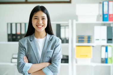 Kendine güvenen genç bir Asyalı kadının portresi kameraya gülümsüyor..