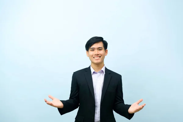 亚洲年轻聪明的快乐商人的画像 穿着西服 站在那里 微笑着 张开双臂欢迎着他 有着孤立的浅蓝色背景 业务概念 — 图库照片