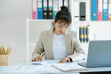 Accountant is working on her desk about budget of the company. She have to calculate the salary of company staff.