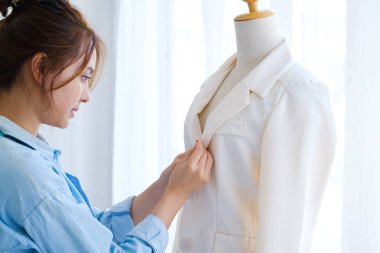 Profesyonel bir moda tasarımcısı model atölyesini ölçüyor ve bir takım elbise tasarlıyor. Yaratılış çalışmasının ve tasarımın bir parçası olarak. Küçük işletme kavramı başlat.