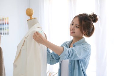 Profesyonel bir moda tasarımcısı model atölyesini ölçüyor ve bir takım elbise tasarlıyor. Yaratılış çalışmasının ve tasarımın bir parçası olarak. Küçük işletme kavramı başlat.