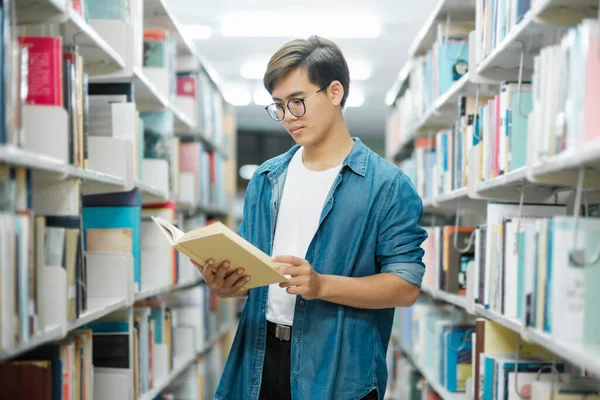 Young Male Student Casual Outfit Backpack Standing Reading Choosing Books — Stock Photo, Image