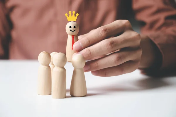 リーダーシップ 募集の概念を示す勝者またはリーダーとして選ばれた王冠と笑顔で木製の駒を保持し 持ち上げる男性の手の閉じる — ストック写真