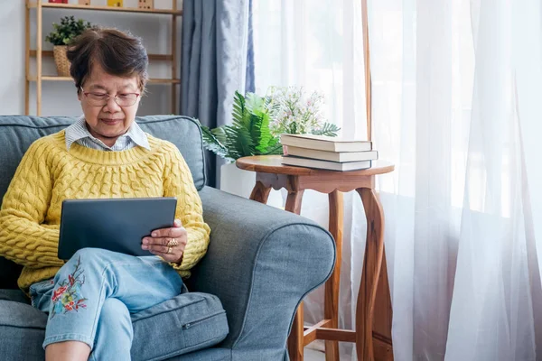 Mature Asian Woman Sits Comfortably Home Immersed Digital World She — Stock Photo, Image
