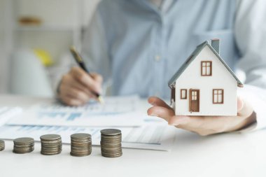 Yatırım evini kredi finansmanı iş konseptiyle kurtarıyorum. Konut emlak işi için yatırım bankacılığı finansmanı. Yatırım kredileri için model evlerin olduğu bozuk paralar. Vergiler için nakit.