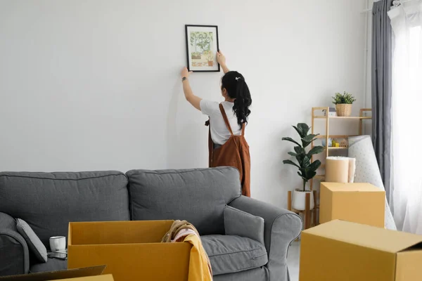 stock image Young Asian woman decorating new home while moving in to new house or apartment.