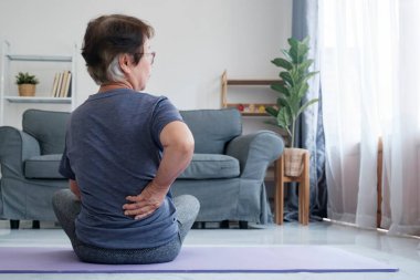 Yaşlı kadın ağrıyan kalçasına dokunuyor. Olgun, yaşlı bir kadının sırtına dokunması... Osteoartrit böbrek ağrısı... Omurga ağrısı... Kaslar....