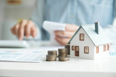 Yatırım evini kredi finansmanı iş konseptiyle kurtarıyorum. Konut emlak işi için yatırım bankacılığı finansmanı. Yatırım kredileri için model evlerin olduğu bozuk paralar. Vergiler için nakit.