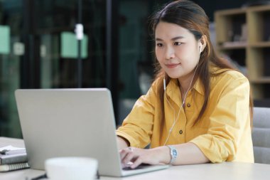 Bilgisayar ve mobil cihaz kullanan genç bir kolaj öğrencisi. Eğitim ve çevrimiçi öğrenim.