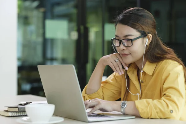 Focused Woman Wearing Headphones Using Laptop Writing Notes Attractive Female — Stock fotografie