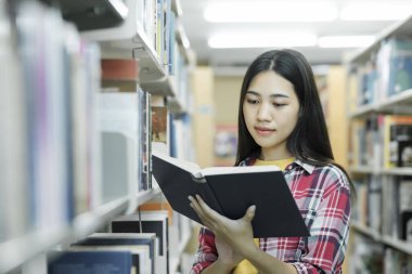 Araştırma için kitap okuyan üniversite öğrencileri ve raporları, ödevleri, makaleleri ve derslere sunumları desteklemek için kütüphanede çeşitli araştırma kaynakları okuyorlar. Eğitim kavramı