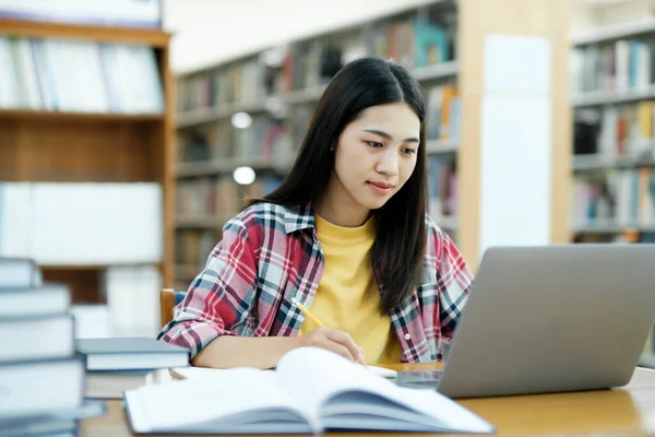 大学图书馆 聪明的亚洲大学生使用笔记本电脑 论文笔记 课堂作业学习 以学生为重点的学习 为高考而学习 — 图库照片