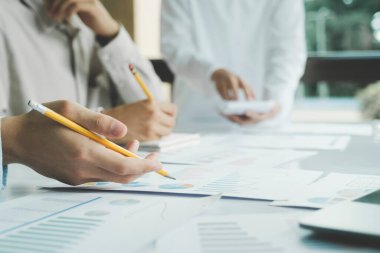 Takım çalışması. Genç işletme yöneticileri yeni bir proje üzerinde çalışıyor. İş ekibi toplantısı ve beyin fırtınası. Yeni başlatılan projeyle çalışan profesyonel fotoğraf ekibi.