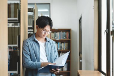 Araştırma için kitap okuyan üniversite öğrencileri ve raporları, ödevleri, makaleleri ve derslere sunumları desteklemek için kütüphanede çeşitli araştırma kaynakları okuyorlar. Eğitim kavramı