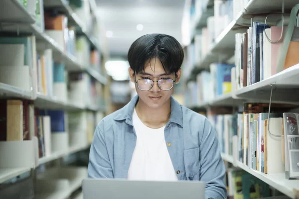 Biblioteka Uniwersytecka Inteligentny Student Uniwersytetu Azjatyckiego Używa Laptopa Pisze Notatki — Zdjęcie stockowe