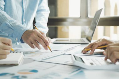 Takım çalışması. Genç işletme yöneticileri yeni bir proje üzerinde çalışıyor. İş ekibi toplantısı ve beyin fırtınası. Yeni başlatılan projeyle çalışan profesyonel fotoğraf ekibi.