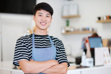 Bar tezgahının yanında duran önlüklü Mutlu Kahve Dükkanı sahibi. Küçük işletme sahibi, restoran sahibi, barista, cafe, Online, KME, girişimci ve satıcı konsepti. Başarılı Restoran Müdürü Ayakta Duruyor