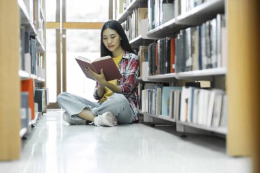 Araştırma için kitap okuyan üniversite öğrencileri ve raporları, ödevleri, makaleleri ve derslere sunumları desteklemek için kütüphanede çeşitli araştırma kaynakları okuyorlar. Eğitim kavramı