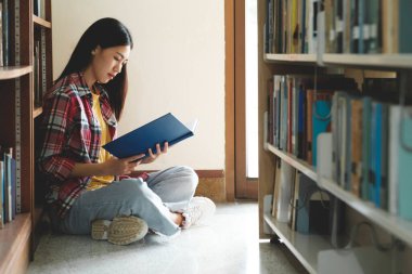 Araştırma için kitap okuyan üniversite öğrencileri ve raporları, ödevleri, makaleleri ve derslere sunumları desteklemek için kütüphanede çeşitli araştırma kaynakları okuyorlar. Eğitim kavramı