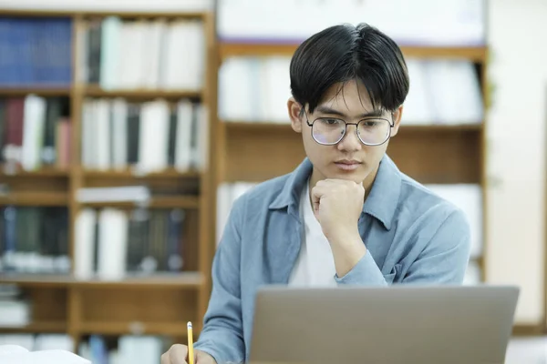 Universitätsbibliothek Intelligenter Asiatischer Student Nutzt Laptop Schreibt Notizen Für Papier — Stockfoto