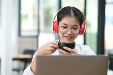 Çevrimiçi eğitim, e-öğrenme. Bilgisayar ve mobil cihaz kullanan genç bir kolaj öğrencisi. Asyalı genç öğrenci çevrimiçi öğrenim sınıfı çalışması Zoom hocası adı verilen online video eğitimi.