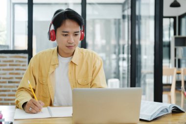 Çevrimiçi eğitim, e-öğrenme. Bilgisayar ve mobil cihaz kullanan genç bir kolaj öğrencisi. Asyalı genç öğrenci çevrimiçi öğrenim sınıfı çalışması Zoom hocası adı verilen online video eğitimi.