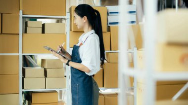 Mutlu girişimciler siparişleri kontrol etmek için tablet kullanır ve müşterilere mal teslimatı için hisse senetlerini kontrol ederler. Küçük işletme sahibi ve çevrimiçi iş kavramlarında başarı.