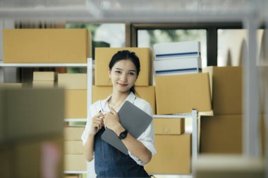 Mutlu girişimciler siparişleri kontrol etmek için tablet kullanır ve müşterilere mal teslimatı için hisse senetlerini kontrol ederler. Küçük işletme sahibi ve çevrimiçi iş kavramlarında başarı.