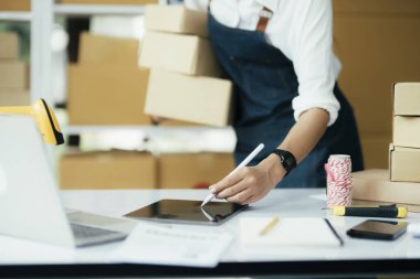 Mutlu girişimciler siparişleri kontrol etmek için tablet kullanır ve müşterilere mal teslimatı için hisse senetlerini kontrol ederler. Küçük işletme sahibi ve çevrimiçi iş kavramlarında başarı.